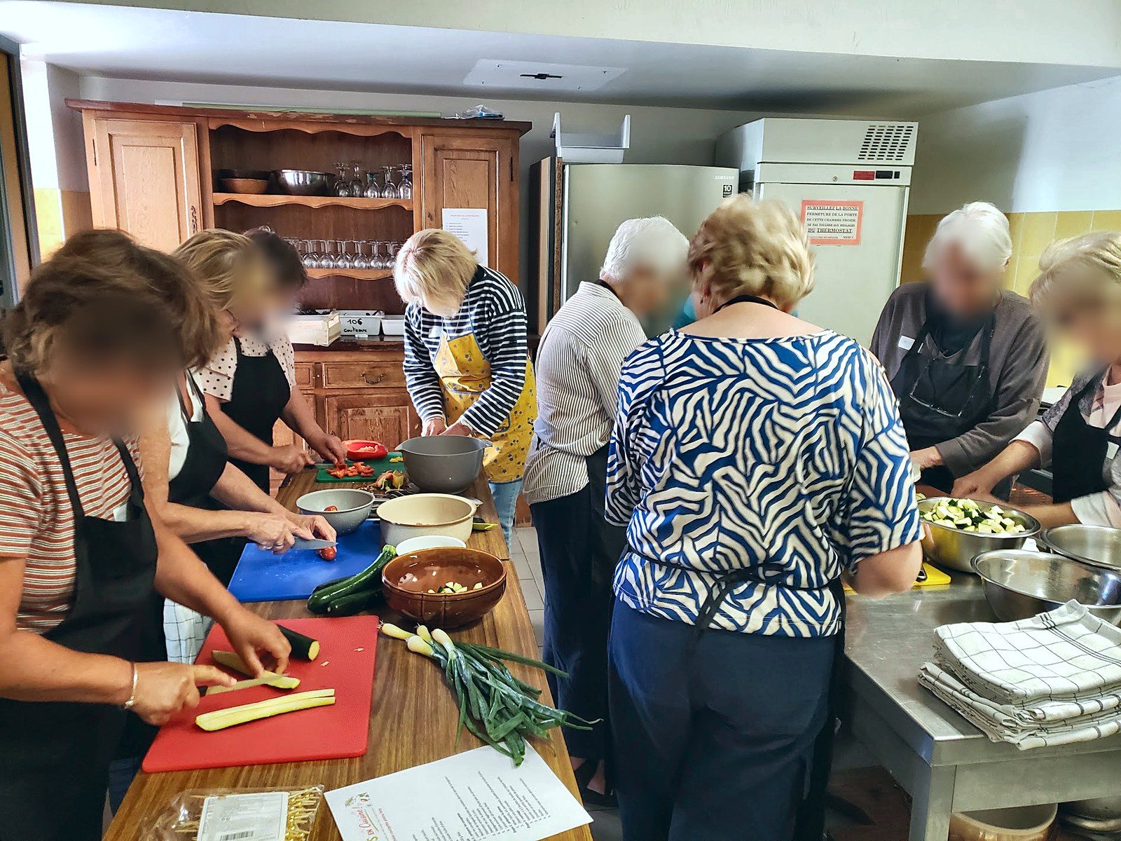 Participantes de l'atelier de Briançonnet préparant des légumes dans la cuisine partagée